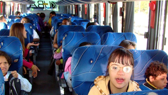 A foto mostra crianças sentadas dentro de um ônibus durante uma excursão do projeto Cultura Acessível Itinerante. 